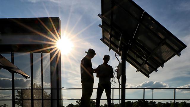Two students examine solar panels outside CTEC